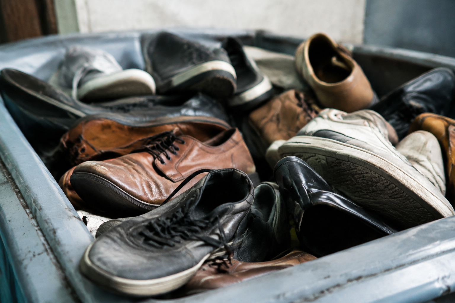 Vieux souliers empiles dans un bac